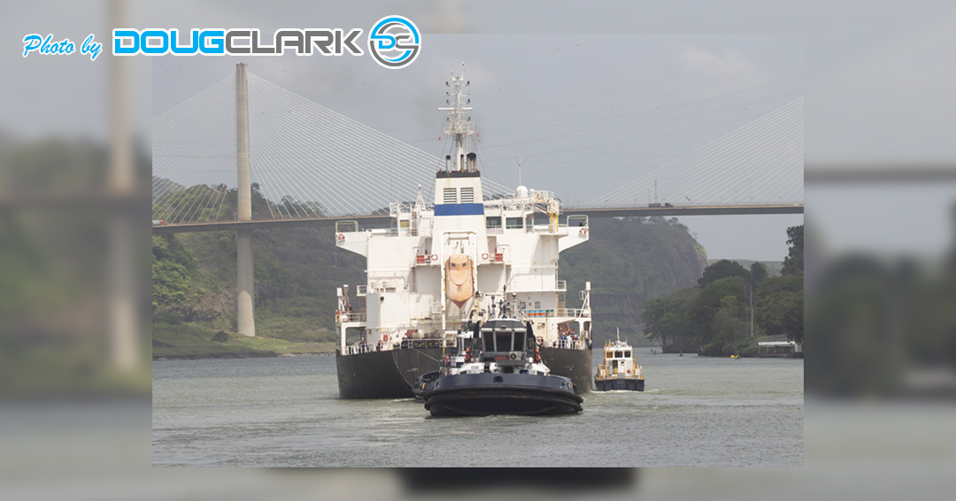 Tugboat pulling cargo vessel through the Panama Canal