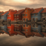 Row of colourful houses perfectly reflected in still water, symbolising reciprocity and mirrored behaviour